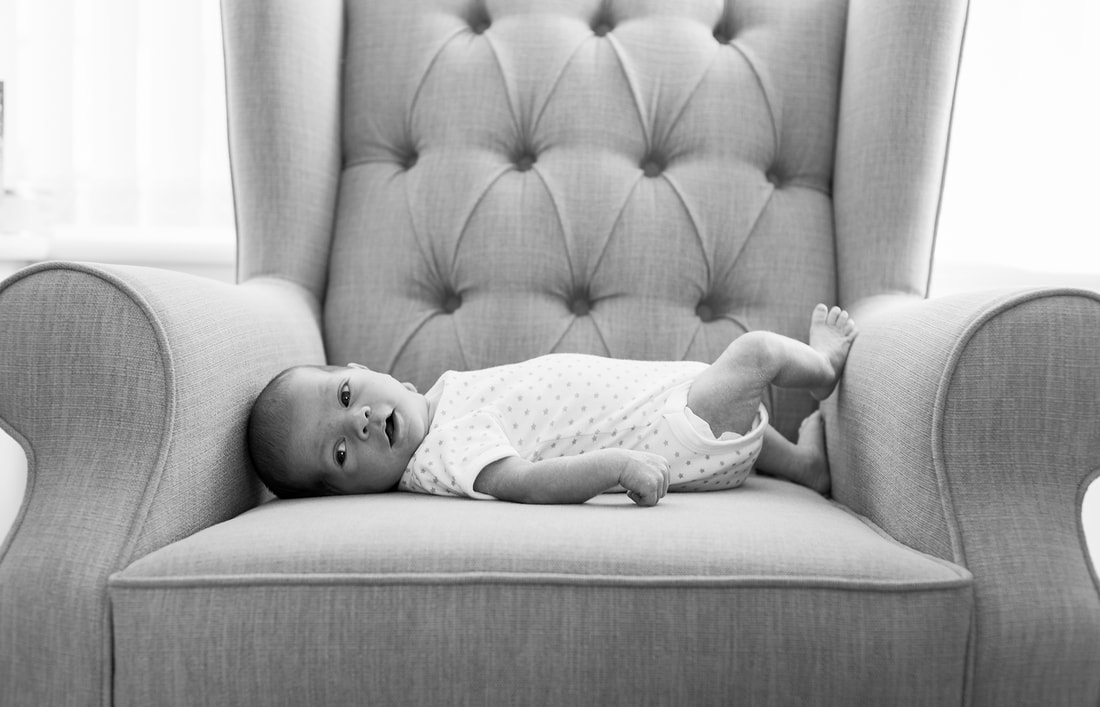 young baby laying on an armchair 