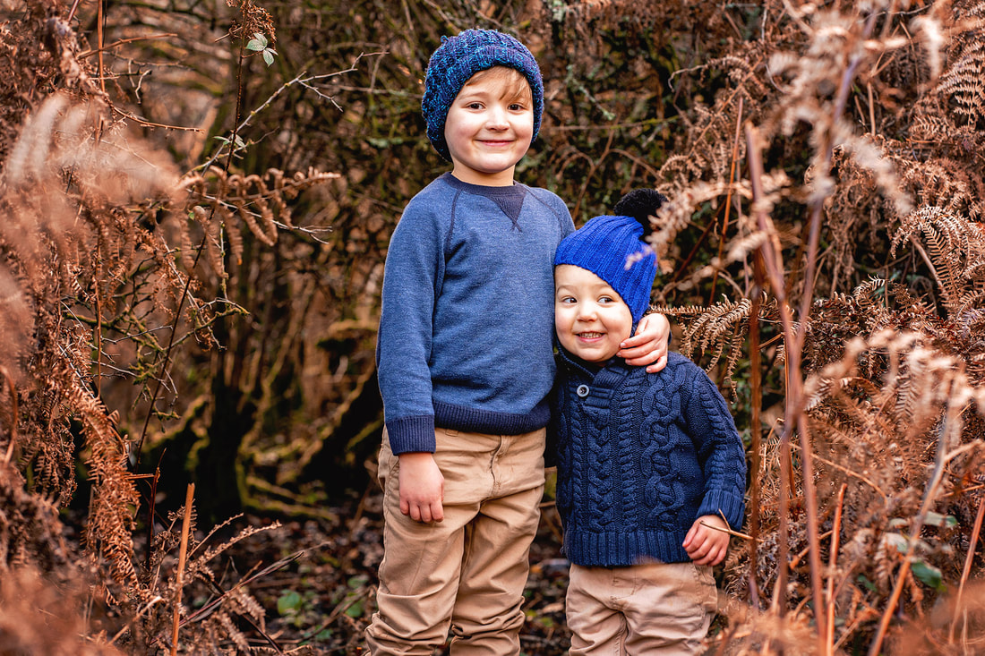 two boys wearing beanies in forest 