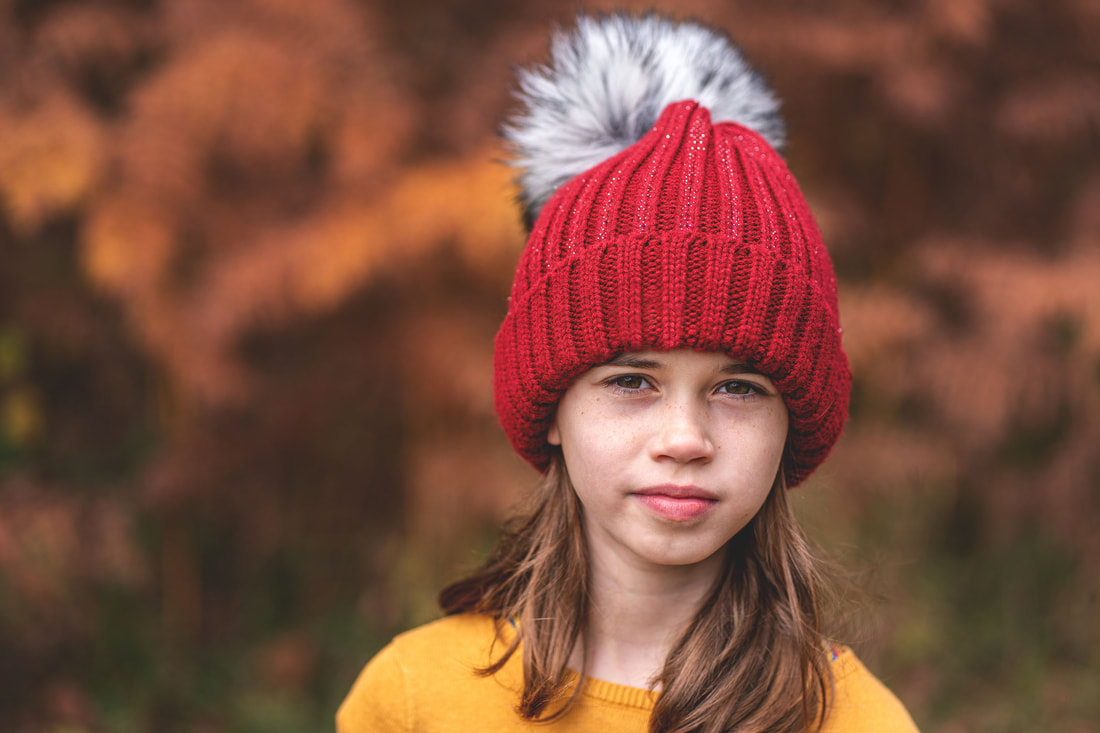 girl wearing red beanie hat in forest 