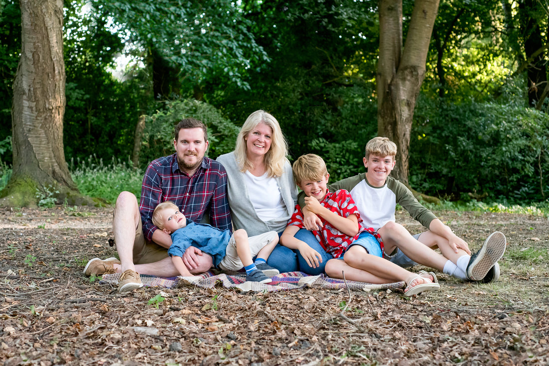family sat together in woodland 